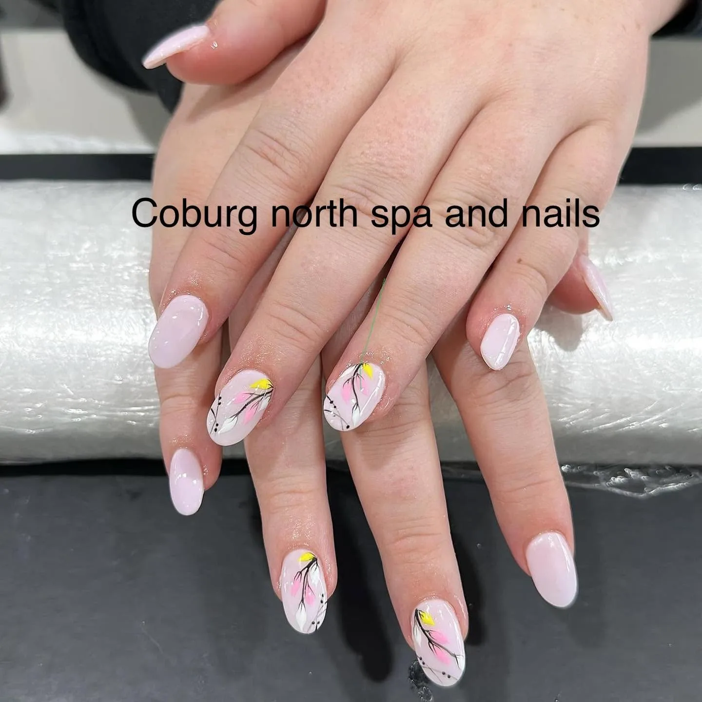 Oval milky-pink nails with delicate black-branch and pink blossom hand-painted art